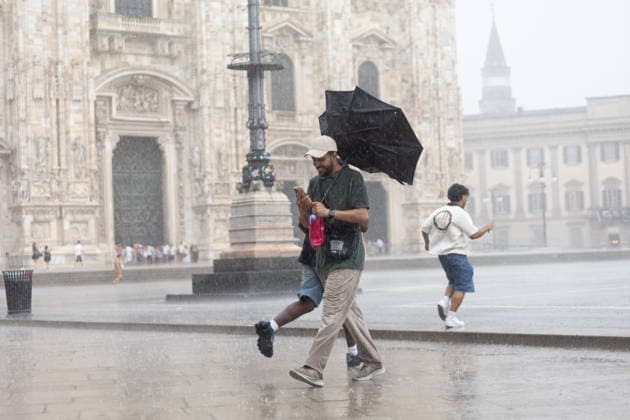 IPA86706239 - Milan, July 15, 2026, Piazza Duomo, summer thunderstorm, downpour, rain, people seeking shelter, tourists, umbrellas, wind  Copyright: xFrancescoxEnriquezx xFrancescoxEnriquezx 86706239