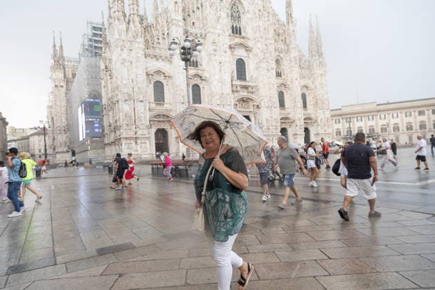 Summer Thunderstorm - Milan Tourists and locals seek shelter under umbrellas as a sudden summer thunderstorm brings heavy rain and strong winds to Piazza Duomo in Milan, Italy on July 15, 2026. Photo by Francesco Enriquez IPA ABACAPRESS.COM Milano  Copyright: xIPA ABACAx