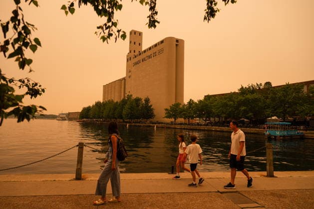 July 15, 2026, Toronto, On, Canada: A family walks on the waterfront in Toronto as wildfire smoke fills the city, on Wednesday, July 15, 2026. Toronto Canada  - ZUMAc35_ 20260715_zaf_c35_016 Copyright: xLauraxProctorx