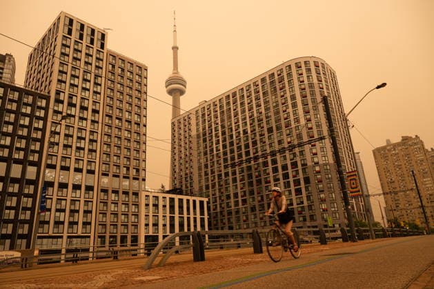 July 15, 2026, Toronto, On, Canada: A woman bikes along the waterfront in Toronto as wildfire smoke fills the city, on Wednesday, July 15, 2026. Toronto Canada  - ZUMAc35_ 20260715_zaf_c35_017 Copyright: xLauraxProctorx