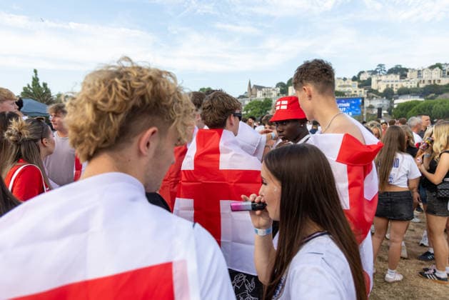 Public Viewing England - Argentinien in Torquay Torquay, England- 15.7.2026: Fußballfans aus Torquay bereiten sich bei einem Public Viewing am Hafen von Torquay auf das Fussballspiel England gegen Argentinien bei der WM 2026 heute abend vor. England steht im Halbfinale der Weltmeisterschaft 2026 gegen Argentinien und kann zum zweiten Mal in seiner Geschichte nach 1966 Weltmeister im Männerfußball werden England