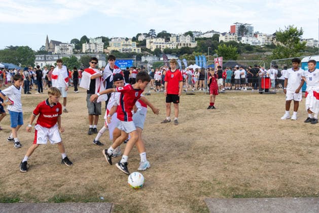 Public Viewing England - Argentinien in Torquay Torquay, England- 15.7.2026: Fußballfans aus Torquay bereiten sich bei einem Public Viewing am Hafen von Torquay auf das Fussballspiel England gegen Argentinien bei der WM 2026 heute abend vor. England steht im Halbfinale der Weltmeisterschaft 2026 gegen Argentinien und kann zum zweiten Mal in seiner Geschichte nach 1966 Weltmeister im Männerfußball werden England