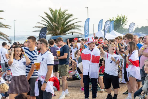 Public Viewing England - Argentinien in Torquay Torquay, England- 15.7.2026: Fußballfans aus Torquay bereiten sich bei einem Public Viewing am Hafen von Torquay auf das Fussballspiel England gegen Argentinien bei der WM 2026 heute abend vor. England steht im Halbfinale der Weltmeisterschaft 2026 gegen Argentinien und kann zum zweiten Mal in seiner Geschichte nach 1966 Weltmeister im Männerfußball werden England