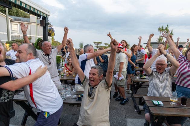 Public Viewing England - Argentinien in Torquay Torquay, England- 15.7.2026: Fußballfans aus Torquay feiern bei einem Public Viewing in einem Pub am Hafen von Torquay das 1:0 für England durch Anthony Gordon während des Fussballspiels England gegen Argentinien bei der WM 2026. England steht im Halbfinale der Weltmeisterschaft 2026 gegen Argentinien und kann zum zweiten Mal in seiner Geschichte nach 1966 Weltmeister im Männerfußball werden England