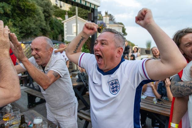 Public Viewing England - Argentinien in Torquay Torquay, England- 15.7.2026: Fußballfans aus Torquay feiern bei einem Public Viewing in einem Pub am Hafen von Torquay das 1:0 für England durch Anthony Gordon während des Fussballspiels England gegen Argentinien bei der WM 2026. England steht im Halbfinale der Weltmeisterschaft 2026 gegen Argentinien und kann zum zweiten Mal in seiner Geschichte nach 1966 Weltmeister im Männerfußball werden England