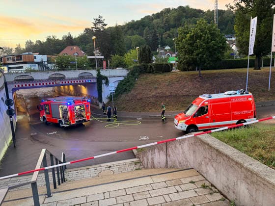 Flut im Taubental: Fans schauen trotz Hochwasser an der Rems wei, Eine Gewitterzelle flutete zwei Unterführungen im Taubental in Schwäbisch Gmünd. Während die Feuerwehr gemeinsam mit den Stadtwerken an der Lindenfirststraße blockierte Einlassrechen von Geäst befreite und die Straße wieder passierbar machten, bewiesen Fußballfans direkt an der hochwasserführenden Rems eiserne Nerven: Sie verfolgten das Spiel England gegen Argentinien völlig unbeeindruckt von den Wassermassen. Schwäbisch Gmünd Baden Württemberg Deutschland *** Flooding in the Taubental: Fans Watch the Game Despite Flooding Along the Rems—A thunderstorm cell flooded two underpasses in the Taubental in Schwäbisch Gmünd. While the fire department, together with the