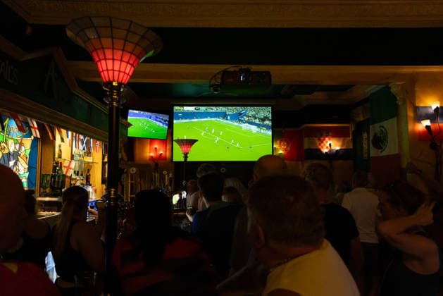 Public Viewing England - Argentinien in Torquay Torquay, England- 15.7.2026: Fußballfans aus Torquay bei einem Public Viewing in einem Pub am Hafen von Torquay während des Fussballspiels England gegen Argentinien bei der WM 2026. England steht im Halbfinale der Weltmeisterschaft 2026 gegen Argentinien und kann zum zweiten Mal in seiner Geschichte nach 1966 Weltmeister im Männerfußball werden England
