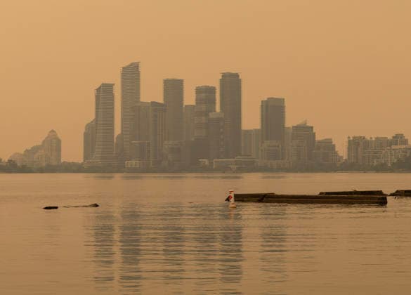(260715) -- TORONTO, July 15, 2026 -- Wildfire smoke from northwestern Ontario fills the sky in Toronto, Canada, on July 15, 2026. Wildfires sweeping across northwestern Ontario, Canada, in recent days have caused severe smog and a sharp deterioration in air quality in several regions, including Ottawa, the nation s capital, and Toronto, Canada s largest city. (Photo by Zou Zheng Xinhua) CANADA-TORONTO-WILDFIRE-AIR QUALITY LinxWei 