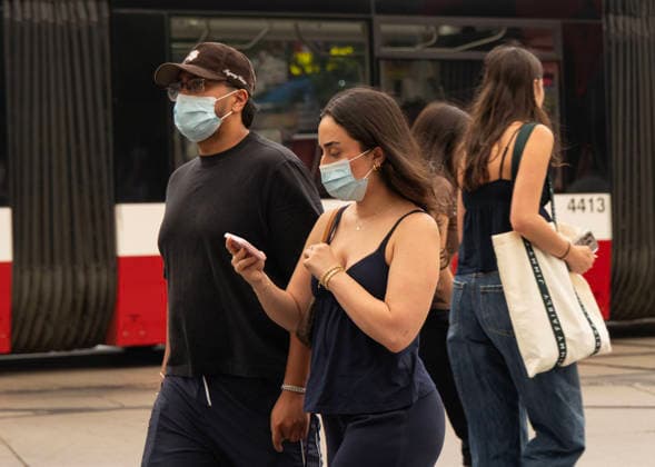 (260715) -- TORONTO, July 15, 2026 -- People wearing face masks walk on the street as wildfire smoke from northwestern Ontario fills the sky in Toronto, Canada, on July 15, 2026. Wildfires sweeping across northwestern Ontario, Canada, in recent days have caused severe smog and a sharp deterioration in air quality in several regions, including Ottawa, the nation s capital, and Toronto, Canada s largest city. (Photo by Zou Zheng Xinhua) CANADA-TORONTO-WILDFIRE-AIR QUALITY LinxWei 