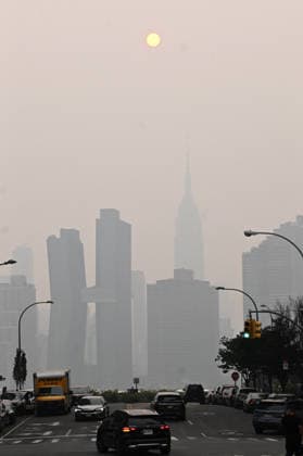 July 16, 2026, New York, New York, USA: July 16, 2026 - New York, NY, USA - New York City midtown skyline with the Empire State Building seen across the East River is masked by smoke coming from the ongoing Canadian wildfires. New Yorkers out with their families, friends, and pets go about their lives as they navigate the smoked filled air. (Andrea RENAULT Zuma Press) New York USA - ZUMAg115 20260716_faf_g115_051 Copyright: xAndreaxRenaultx
