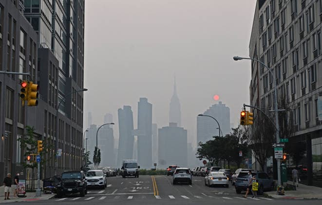 July 16, 2026, New York, New York, USA: July 16, 2026 - New York, NY, USA - New York City midtown skyline with the Empire State Building seen across the East River is masked by smoke coming from the ongoing Canadian wildfires. New Yorkers out with their families, friends, and pets go about their lives as they navigate the smoked filled air. (Andrea RENAULT Zuma Press) New York USA - ZUMAg115 20260716_faf_g115_052 Copyright: xAndreaxRenaultx