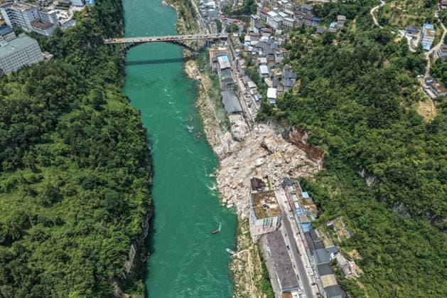 (260717) -- CHONGQING, July 17, 2026 -- An aerial drone photo taken on July 17, 2026 shows the site of a rainfall-induced landslide along a section of the Wujiang River in southwest China s Chongqing Municipality. Nine people have so far been rescued after a rainfall-induced landslide occurred along a section of the Wujiang River in southwest China s Chongqing Municipality on Friday. None of those rescued sustained life-threatening injuries, according to local authorities of Pengshui Miao and Tujia Autonomous County in Chongqing. The geological disaster saw massive amounts of rock and soil wash downslope at 9:08 a.m. Friday, burying more than 10 residential buildings, leaving local residents trapped and unaccounted for. ) (SpotNews) 