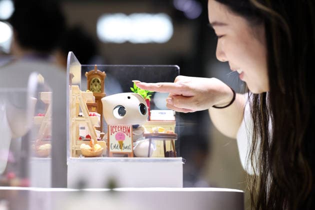 SHANGHAI, CHINA - JULY 17: A visitor interacts with a desktop robot during the 2026 World AI Conference and High-Level Meeting on Global AI Governance on July 17, 2026 in Shanghai, China. Themed AI Partnership for a Brighter Future, the event will include more than 140 forums, bringing together 1,400 guests from home and abroad.  Copyright: xChinaxNewsxServicex 111654825222