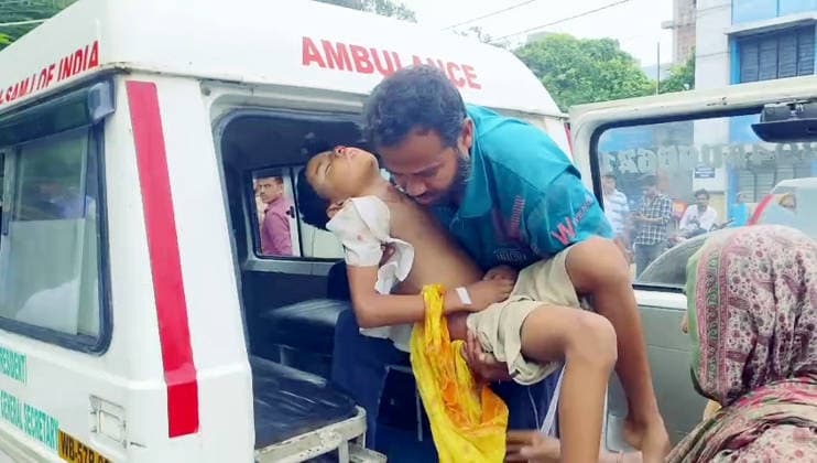 RECORD DATE NOT STATED A man carries an injured student out of an ambulance following a vehicle carrying school students was hit by a train at a railway level crossing Murshidabad, Jul 17 (ANI): A man carries an injured student out of an ambulance following a vehicle carrying school students was hit by a train at a railway level crossing at Karnasuvarna, in Murshidabad on Friday. (ANI Video Grab) Murshidabad West Bengal India Copyright: xANIx ANI_20260717179