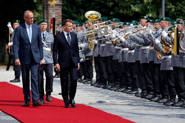 Frankreichs Präsident Emmanuel Macron (PS) und Bundeskanzler Friedrich Merz (CDU) schreiten seitwärts an Soldaten über den roten Teppich beim Empfang mit militärischen Ehren auf Schloss Augustusburg beim 26. Deutsch-Französischen Ministerrat. Die Regierungen beider Länder kommen zusammen, um nicht nur die militärische Zusammenarbeit sondern auch Kooperationen in den Bereichen Forschung und Wirtschaft abzustimmen. Brühl, 17.07.2026 NRW Deutschland *** French President Emmanuel Macron (PS) and German Chancellor Friedrich Merz (CDU) walk side by side past soldiers on the red carpet during a reception with military honors at Augustusburg Castle on the occasion of the 26th Franco-German Ministerial Council. The governments of both countr Copyright: xChristophxHardtx