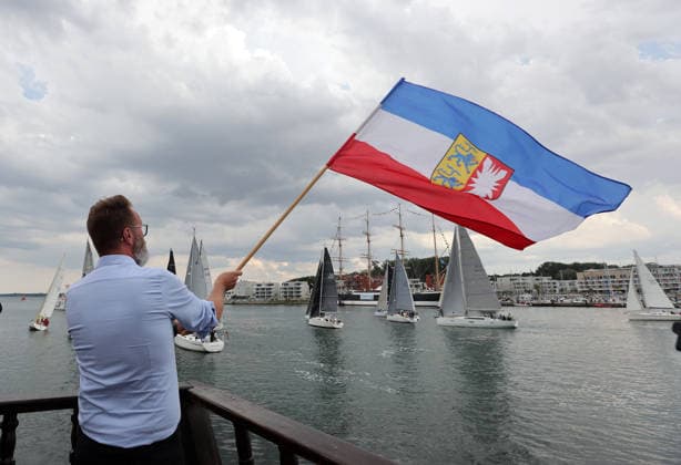 Wirtschaftsminister Schleswig Holstein, Claus Ruhe Madsen startet die erste Regatta der diesjaehrigen Travemuender Woche mit dem Schwenken der Landesfahne Impressionen der Eroeffung der 137.Travemuender Woche Reisen, Tourismus, urlaub, Ferien, Ostsee, Travemuende, Segelsport Travemuende *** Schleswig-Holstein Minister of Economic Affairs, Claus Ruhe Madsen kicks off the first regatta of this year’s Travemünde Week by raising the state flag. Highlights from the opening of the 137th Travemünde Week. Travel, tourism, vacation, holidays, Baltic Sea, Travemünde, sailing in Travemünde