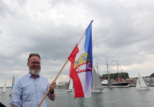 Wirtschaftsminister Schleswig Holstein, Claus Ruhe Madsen startet die erste Regatta der diesjaehrigen Travemuender Woche mit dem Schwenken der Landesfahne Impressionen der Eroeffung der 137.Travemuender Woche Reisen, Tourismus, urlaub, Ferien, Ostsee, Travemuende, Segelsport Travemuende *** Schleswig-Holstein Minister of Economic Affairs, Claus Ruhe Madsen kicks off the first regatta of this year’s Travemünde Week by raising the state flag. Highlights from the opening of the 137th Travemünde Week. Travel, tourism, vacation, holidays, Baltic Sea, Travemünde, sailing in Travemünde