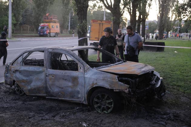 July 17, 2026, Kharkiv, Kharkiv Oblast, UKRAINE: A severely fire-damaged sedan with blown-out windows sits in a park near trees and emergency vehicles in Shevchenkivskyi District, Kharkiv, Ukraine, on July 17, 2026, following a russian Banderol missile strike. A 40-year-old man was killed inside the vehicle; nine others were injured including two children, a seven-year-old with blast injuries and a two-year-old in acute stress reaction. Emergency responders and civilians examine the destruction at the scene. Kharkiv UKRAINE  - ZUMAt164 20260717_zip_t164_007 Copyright: xYevhenxTitovx