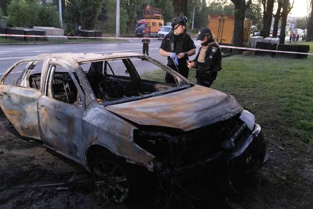 July 17, 2026, Kharkiv, Kharkiv Oblast, Ukraine: A burnt-out sedan with blown-out windows and severely damaged hood lies on grass following a russian Banderol missile attack in Shevchenkivskyi District, Kharkiv, Ukraine on July 17, 2026. Two police officers in tactical gear examine the destroyed vehicle at the cordoned-off scene. The strike killed a 40-year-old man inside the vehicle and wounded seven others who were hospitalized; a school building and several commercial structures were also damaged. Kharkiv Ukraine  - ZUMAt164 20260717_zip_t164_009 Copyright: xYevhenxTitovx