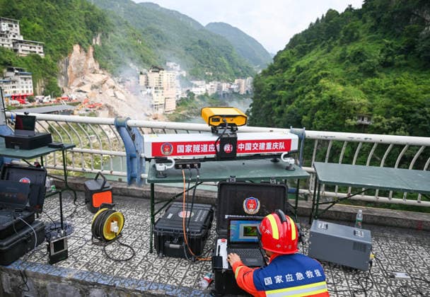 (260718) -- CHONGQING, July 18, 2026 -- A rescuer monitors the stability of the mountainside near the site of a mountain collapse in Pengshui Miao and Tujia Autonomous County, southwest China s Chongqing Municipality, July 17, 2026. Eight people have been confirmed dead and 34 others remain missing after a rainfall-induced mountain collapse occurred along a section of the Wujiang River in southwest China s Chongqing Municipality on Friday, local authorities said. Ten people have been rescued, and search and rescue operations are underway, according to a press briefing held on Friday night. The geological disaster occurred at 9:08 a.m. on Friday in the Hanjia sub-district of Pengshui Miao and Tujia Autonomous County in Chongqing, bury 