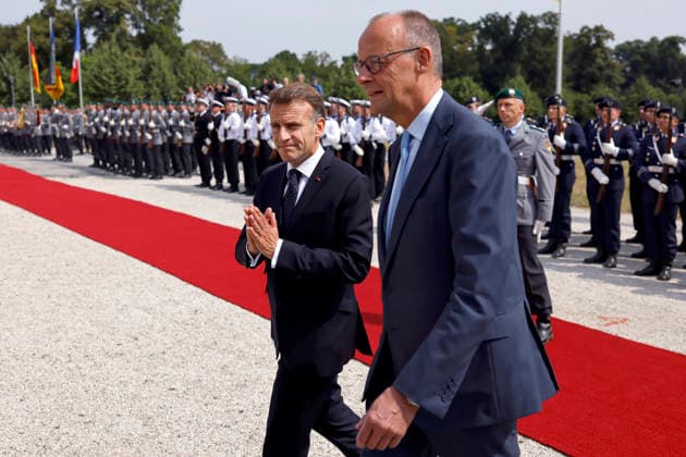 Frankreichs Präsident Emmanuel Macron (PS) und Bundeskanzler Friedrich Merz (CDU) schreiten seitwärts an Soldaten über den roten Teppich beim Empfang mit militärischen Ehren auf Schloss Augustusburg beim 26. Deutsch-Französischen Ministerrat. Die Regierungen beider Länder kommen zusammen, um nicht nur die militärische Zusammenarbeit sondern auch Kooperationen in den Bereichen Forschung und Wirtschaft abzustimmen. Brühl, 17.07.2026 NRW Deutschland *** French President Emmanuel Macron (PS) and German Chancellor Friedrich Merz (CDU) walk side by side past soldiers on the red carpet during a reception with military honors at Augustusburg Castle on the occasion of the 26th Franco-German Ministerial Council. The governments of both countr Copyright: xChristophxHardtx
