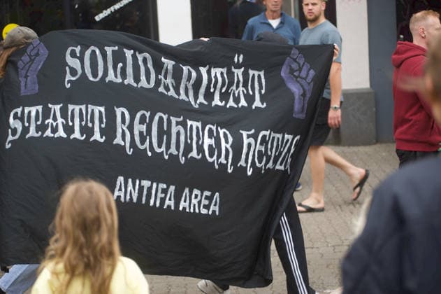 Flensburg, Schleswig-Holstein Demo ProjektM1llion öEinigkeit für Deutschland™. Gegendemonstranten aus der linken Szene halten Transparent weißer Text auf schwarzen Hintergrund, Solidarität statt rechter Hetze. Antifa Area. Aufnahme vom 18.07.2026, Flensburg. *** Flensburg, Schleswig-Holstein: M1llion Unity for Germany™ demonstration. Counter-protesters from the left-wing scene hold a banner with white text on a black background reading Solidarity instead of right-wing hate speech. Photo taken in the Antifa Area on July 18, 2026, in Flensburg.