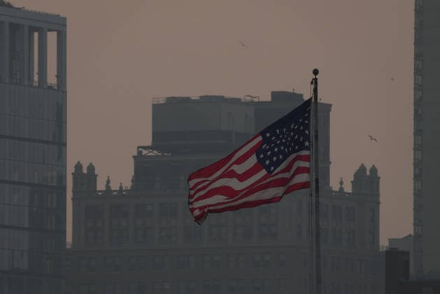 July 18, 2026, New York, New York, USA: An American flag flies as the smoke from Canadian Wildfires hangs over Manhattan on July 18, 2026 in New York. More than 200 wildfires are burning in Canada causing smoke to drift across the United States spiking the air quality index. New York USA - ZUMAb148 20260718_zap_b148_006 Copyright: xBryanxSmithx