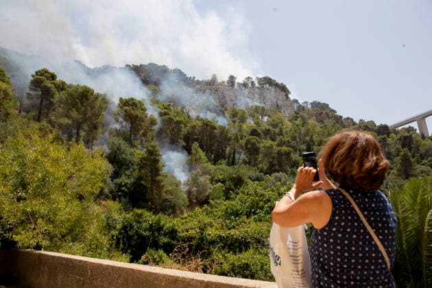 Wildfire Spreads Amid Heatwave in Sicily A woman films a wildfire from a nearby area in Modica, Sicily, Italy, on July 18, 2026. Wildfires were reported in parts of Sicily as high temperatures persisted across the region. Modica Sicily Italy Copyright: xElvisxTakahashixMantellox