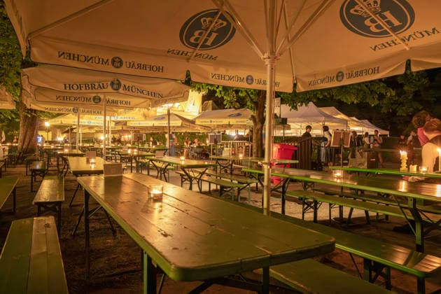 Kocherlball am Chinesischen Turm, Biertrinken bei Kerzenschein, reservierter Bereich um 4:15 Uhr noch leer, füllt sich kurz darauf, München, 19. Juli 2026 Deutschland, München, 19. Juli 2026, Biertrinken bei Kerzenschein, traditioneller Kocherlball am Chinesischen Turm, Englischer Garten, reservierter Bereich um 4:15 Uhr noch leer, während im unreservierten Bereich alles schon bis auf den letzten Platz besetzt ist, im reservierten Bereich treffen die Besucher bis 5 Uhr ein, dann ist es ebenfalls voll, manche Besuche rsind schon um 3 Uhr früh im Biergarten, um noch einen Platz zu ergattern, die Menschen trinken ein Bier, essen eine Brotzeit, tragen Tracht, Tradition entstand im 19. Jahrhundert, als Hauspersonal, Dienstboten und KöchInn