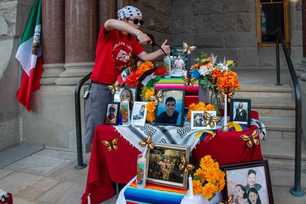 July 18, 2026, Salt Lake City, Utah, USA: A protester lights candles at a temporary altar featuring flowers and photographs of various victims outside the Salt Lake City and County Building at Washington Square Park during an ICE OUT protest in Salt Lake City, Utah, on Saturday, July 18, 2026. The demonstration was organized to contest immigration policy following the recent fatal shootings of Lorenzo Salgado Araujo and Joan Sebastian Guerrero by federal immigration law enforcement agents. Salt Lake City USA  - ZUMAm292 20260718_znp_m292_007 Copyright: xCharlesxMcClintockxWilsonx