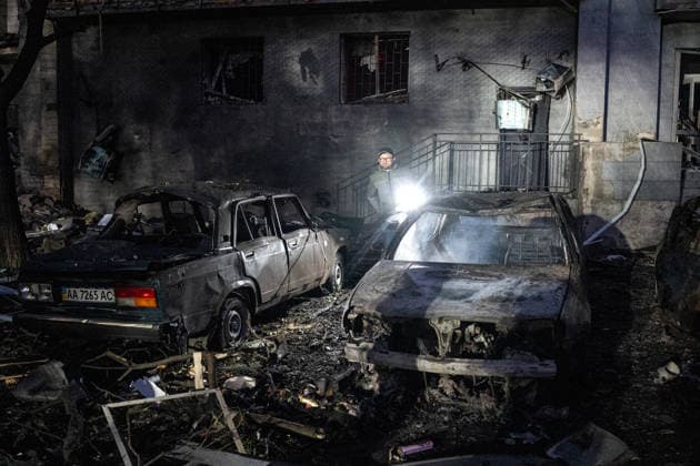 A man lights his way as he walks between two destroyed cars in the Solomianskyi district after a Russian attack on Kyiv, Ukraine, July 19, 2026. The Russian army launched a massive strike on the Ukrainian capital with ballistic missiles. According to preliminary data from the State Emergency Service of Ukraine, one person was killed and 15 were injured. Falling debris and fires were reported in five districts of the city, while an underpass near the Lukianivska metro station sustained a direct hit. (Photo by Danylo Antoniuk Ukrinform) Russian army attack Kyiv with ballistic missiles  Copyright: xDanyloxAntoniukx