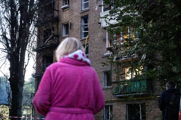 A woman in a pink bathrobe faces a five-storey apartment block in the Solomianskyi district damaged by a Russian attack on Kyiv, Ukraine, July 19, 2026. The Russian army launched a massive strike on the Ukrainian capital with ballistic missiles. According to preliminary data from the State Emergency Service of Ukraine, one person was killed and 15 were injured. Falling debris and fires were reported in five districts of the city, while an underpass near the Lukianivska metro station sustained a direct hit. (Photo by Danylo Antoniuk Ukrinform) Russian army attacks Kyiv with ballistic missiles  Copyright: xDanyloxAntoniukx