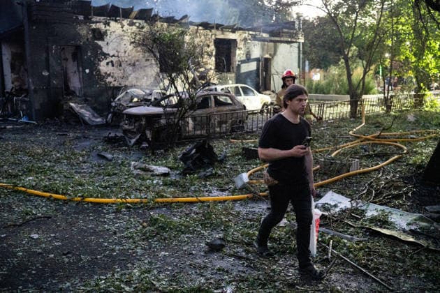 A man walks past a firefighter working at a five-storey apartment block in the Solomianskyi district damaged by a Russian attack on Kyiv, Ukraine, July 19, 2026. The Russian army launched a massive strike on the Ukrainian capital with ballistic missiles. According to preliminary data from the State Emergency Service of Ukraine, one person was killed and 15 were injured. Falling debris and fires were reported in five districts of the city, while an underpass near the Lukianivska metro station sustained a direct hit. (Photo by Danylo Antoniuk Ukrinform) Russian army attacks Kyiv with ballistic missiles  Copyright: xDanyloxAntoniukx