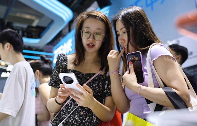(260719) -- SHANGHAI, July 19, 2026 -- Visitors try out an AI agent mobile phone during the 2026 World AI Conference and High-Level Meeting on Global AI Governance in Shanghai, east China, July 19, 2026. The event scheduled from Friday to Monday showcases exhibitions of a number of AI agent hardware and system products, highlighting the transition of next-generation AI from a tool to an intelligent partner, empowering various industries and everyday life. ) CHINA-SHANGHAI-WORLD AI CONFERENCE-AI PRODUCTS (CN) FangxZhe 