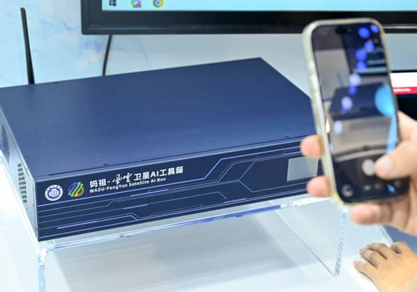 (260719) -- SHANGHAI, July 19, 2026 -- A visitor takes photos of a MAZU-FengYun satellite AI box during the 2026 World AI Conference and High-Level Meeting on Global AI Governance in Shanghai, east China, July 19, 2026. The event scheduled from Friday to Monday showcases exhibitions of a number of AI agent hardware and system products, highlighting the transition of next-generation AI from a tool to an intelligent partner, empowering various industries and everyday life. ) CHINA-SHANGHAI-WORLD AI CONFERENCE-AI PRODUCTS (CN) ChenxHaoming 