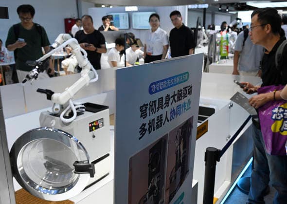 (260719) -- SHANGHAI, July 19, 2026 -- A robot opens the door of a washing machine to load clothes for laundering during the 2026 World AI Conference in Shanghai, east China, July 19, 2026. The ongoing 2026 World AI Conference turns out to be a highly competitive arena for general embodied AI products from more than 200 providers. It refers to a general-purpose intelligence system that enables robots to perform variable tasks and adapt to different application scenarios. ) CHINA-SHANGHAI-WORLD AI CONFERENCE-GENERAL EMBODIED AI (CN) HuangxXiaoyong 