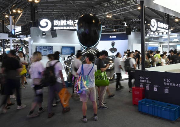 (260719) -- SHANGHAI, July 19, 2026 -- Visitors are seen in front of a robot company s booth during the 2026 World AI Conference in Shanghai, east China, July 19, 2026. The ongoing 2026 World AI Conference turns out to be a highly competitive arena for general embodied AI products from more than 200 providers. It refers to a general-purpose intelligence system that enables robots to perform variable tasks and adapt to different application scenarios. ) CHINA-SHANGHAI-WORLD AI CONFERENCE-GENERAL EMBODIED AI (CN) HuangxXiaoyong 