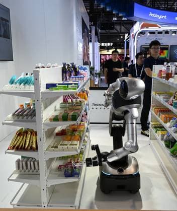 (260719) -- SHANGHAI, July 19, 2026 -- A robot fetches a pack of mock medicine from a shelf during the 2026 World AI Conference in Shanghai, east China, July 19, 2026. The ongoing 2026 World AI Conference turns out to be a highly competitive arena for general embodied AI products from more than 200 providers. It refers to a general-purpose intelligence system that enables robots to perform variable tasks and adapt to different application scenarios. ) CHINA-SHANGHAI-WORLD AI CONFERENCE-GENERAL EMBODIED AI (CN) HuangxXiaoyong 