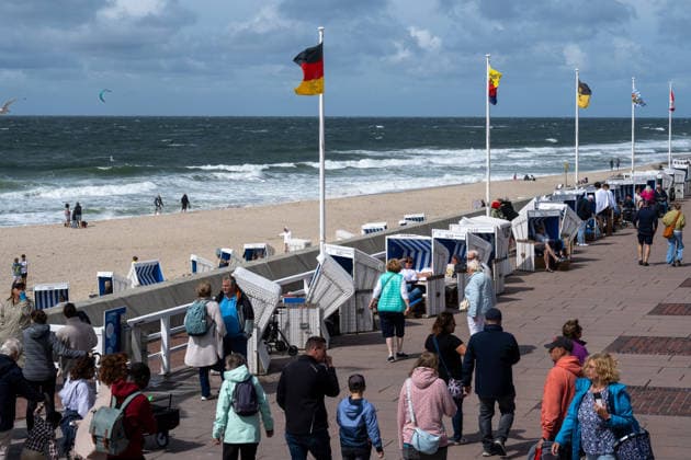 Sommer in Westerland auf Sylt 19.07.2026, Westerland --- Urlauber spazieren an der Strandpromenade des Hauptstrands von Westerland auf Sylt entlang. Am Strand weht eine frische Brise. Westerland Schleswig-Holstein Deutschland *** Summer in Westerland on Sylt, July 19, 2026. Vacationers in Westerland stroll along the boardwalk on Westerland’s main beach on Sylt. A fresh breeze blows across the beach. Westerland, Schleswig-Holstein, Germany