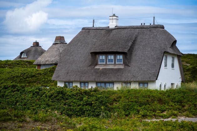 Hörnum auf Sylt 19.07.2026, Hörnum --- Ein reetgedecktes Haus steht in der Dünenlandschaft von Hörnum auf Sylt. Die typische Bauweise prägt den Ort. Hörnum Schleswig-Holstein Deutschland *** Hörnum on Sylt, July 19, 2026, Hörnum: A thatched-roof house stands amid the dunes of Hörnum on Sylt. This traditional architectural style characterizes the town of Hörnum in Schleswig-Holstein, Germany.