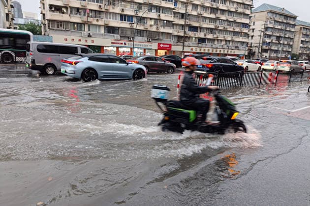 SHANGHAI, CHINA - JULY 19: A motorcyclist drives through flooded street due to heavy rainstorms on July 19, 2026 in Shanghai, China. Shanghai Meteorological Observatory upgraded the rainstorm alert from yellow to orange for the central urban area at 14:35 on July 19.  Copyright: xVCGx 111655213993