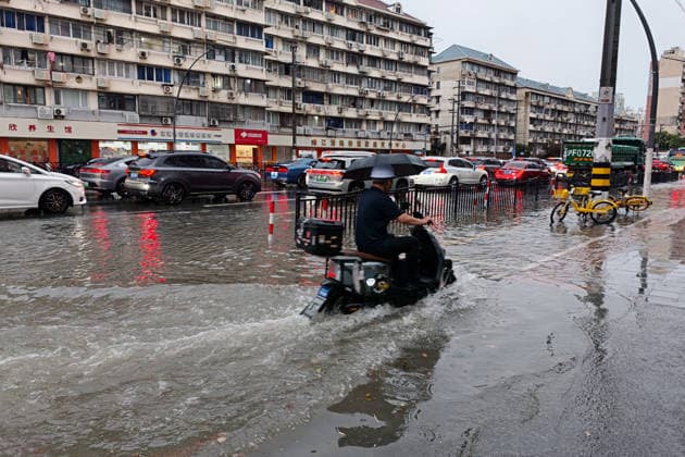 SHANGHAI, CHINA - JULY 19: A motorcyclist drives through flooded street due to heavy rainstorms on July 19, 2026 in Shanghai, China. Shanghai Meteorological Observatory upgraded the rainstorm alert from yellow to orange for the central urban area at 14:35 on July 19.  Copyright: xVCGx 111655213996