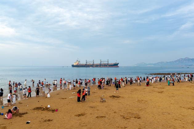 WEIHAI, CHINA - JULY 19: Tourists view the stranded Blueways ship against the sunset glow on July 19, 2026 in Weihai, Shandong Province of China. The vessel was stranded off the coast of Weihai and has become a popular spot for visitors.  Copyright: xVCGx 111655336161
