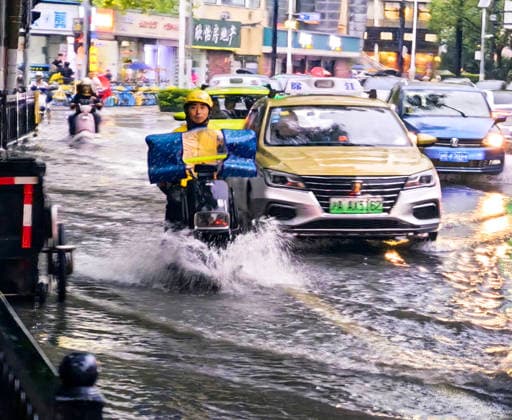 SHANGHAI, CHINA - JULY 19: A motorcyclist drives through flooded street due to heavy rainstorms on July 19, 2026 in Shanghai, China. Heavy rain caused severe waterlogging in roads and residential areas in Shanghai s Yangpu District. Shanghai Meteorological Observatory upgraded the rainstorm alert from yellow to orange for the central urban area at 14:35 on July 19.  Copyright: xVCGx 111655264434