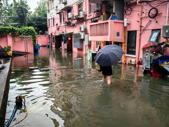 SHANGHAI, CHINA - JULY 19: A resident wades through flooded area in a residential area due to heavy rainstorms on July 19, 2026 in Shanghai, China. Heavy rain caused severe waterlogging in roads and residential areas in Shanghai s Yangpu District. Shanghai Meteorological Observatory upgraded the rainstorm alert from yellow to orange for the central urban area at 14:35 on July 19.  Copyright: xVCGx 111655264435