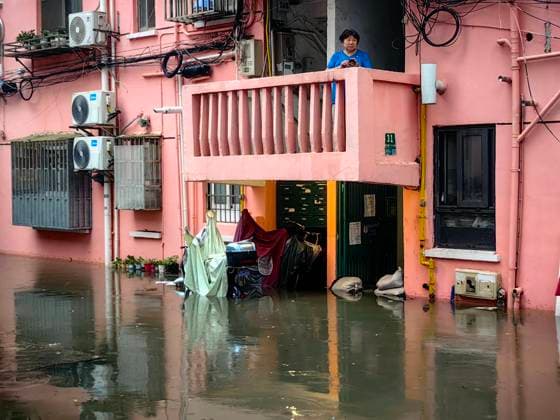 SHANGHAI, CHINA - JULY 19: A resident views flooded area in a residential area due to heavy rainstorms on July 19, 2026 in Shanghai, China. Heavy rain caused severe waterlogging in roads and residential areas in Shanghai s Yangpu District. Shanghai Meteorological Observatory upgraded the rainstorm alert from yellow to orange for the central urban area at 14:35 on July 19.  Copyright: xVCGx 111655264436