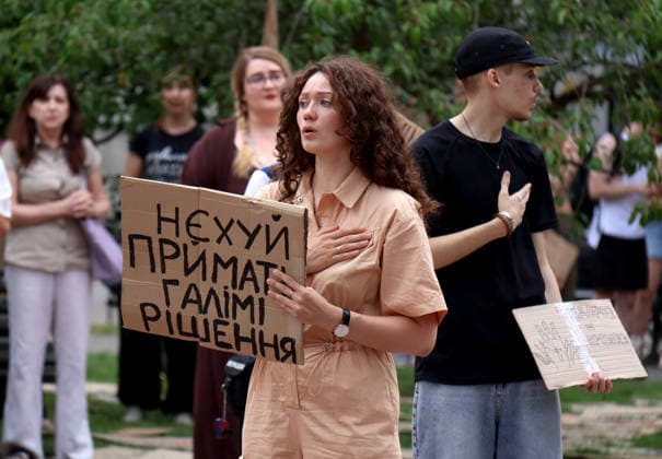A woman with a placard and other demonstrators perform the national anthem with placards during a protest action against the dismissal of Ukrainian Defence Minister Mykhailo Fedorov in Ivana Franka Square outside the Ivan Franko National Academic Drama Theatre and near the Office of the President, Kyiv, Ukraine, July 19, 2026. (Photo by Pavlo Bahmut Ukrinform) Day Four of protest action against dismissal of Mykhailo Fedorov in Kyiv  Copyright: xPavloxBahmutx