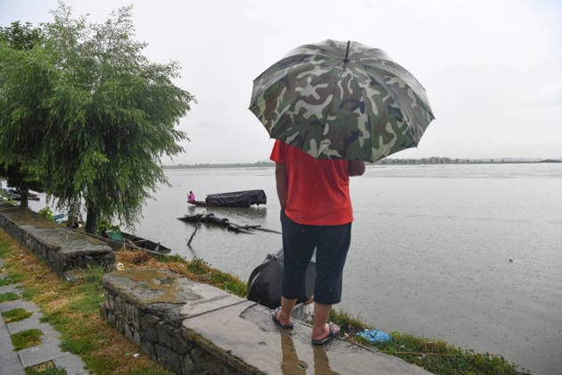 July 20, 2026, Srinagar, Jammu And Kashmir, India: A fisherman rows his boat during heavy rainfall in Srinagar.Torrential rain unleashed flash floods and landslides in Pir Panjal region of J&Ks Poonch and Rajouri districts Sunday, killing at least 14 people, leaving several missing and burying homes under walls of water, rock and mud that barrelled down mountain slopes. Officials said the toll could rise as rescuers searched for those trapped beneath debris. Srinagar India - ZUMAz120 20260720_zip_z120_005 Copyright: xBasitxZargarx