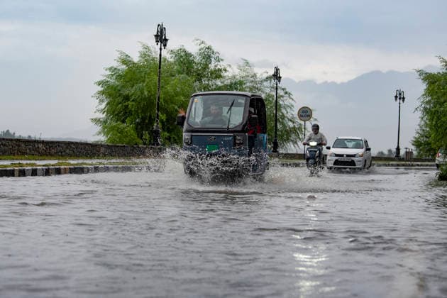 July 20, 2026, Srinagar, Jammu And Kashmir, India: People travel with their vehicles through a waterlogged road during heavy rainfall in Srinagar.Torrential rain unleashed flash floods and landslides in Pir Panjal region of J&Ks Poonch and Rajouri districts Sunday, killing at least 14 people, leaving several missing and burying homes under walls of water, rock and mud that barrelled down mountain slopes. Officials said the toll could rise as rescuers searched for those trapped beneath debris. Srinagar India  - ZUMAz120 20260720_zip_z120_017 Copyright: xBasitxZargarx