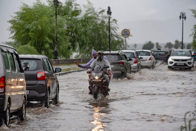 July 20, 2026, Srinagar, Jammu And Kashmir, India: People travel with their vehicles through a waterlogged road during heavy rainfall in Srinagar.Torrential rain unleashed flash floods and landslides in Pir Panjal region of J&Ks Poonch and Rajouri districts Sunday, killing at least 14 people, leaving several missing and burying homes under walls of water, rock and mud that barrelled down mountain slopes. Officials said the toll could rise as rescuers searched for those trapped beneath debris. Srinagar India  - ZUMAz120 20260720_zip_z120_018 Copyright: xBasitxZargarx